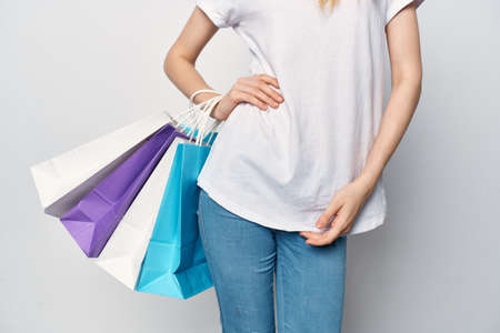 woman in white t-shirt with packages in hands shopping shop