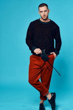 man in trendy streetwear posing studio blue background