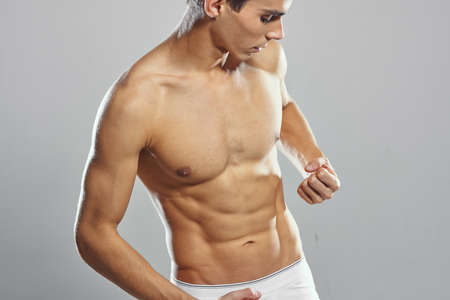 male bodybuilder posing gym light background