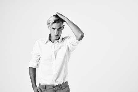 a man in a white shirt gestures with his hands emotions modern style light backgroundの写真素材