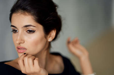 pretty brunette in black dress bracelet on hand studio fashion posingの写真素材