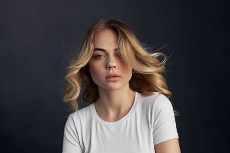 pretty woman in white t-shirt posing fashionable hairstyle dark backgroundの写真素材