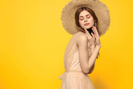 pretty woman in beach hat swimsuit summer lifestyle fashion yellow backgroundの写真素材