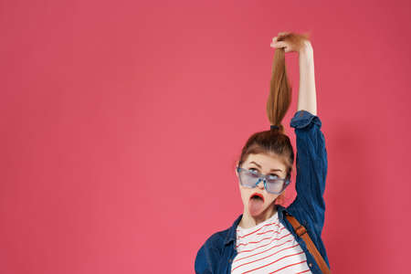 cheerful woman fashionable youth clothes pink background backpackの写真素材