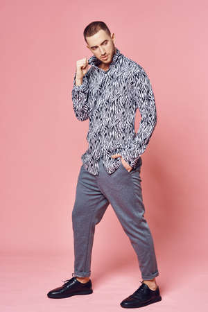 fashionable man shirt posing self confidence pink backgroundの写真素材