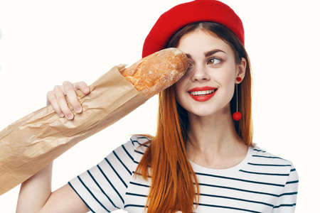 woman in a red hat with a french loaf in her hands a snack Gourmet lifestyleの写真素材