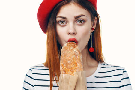 woman in a red hat with a french loaf in her hands a snack Gourmet lifestyleの写真素材