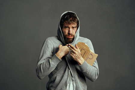 bearded homeless man holding a sign help financial problems bum