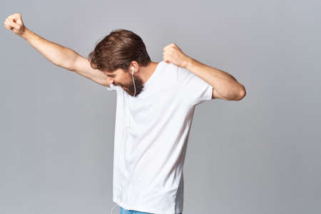 emotional man in white t-shirt fun gesture with hands light backgroundの写真素材
