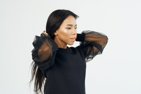 pretty woman with long dark hair cosmetics light backgroundの写真素材