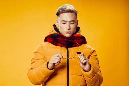 Asian man in winter clothes and checkered scarfの写真素材
