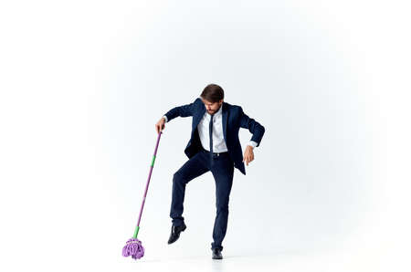 business man in a suit with a mop in his hands providing services cleaning floorsの写真素材