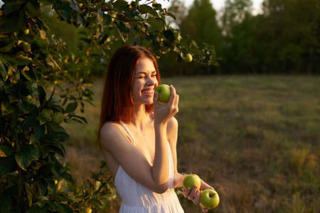 pretty woman in white dress with apples in hands fruit natureの写真素材