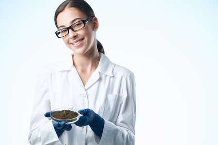 cheerful woman in white coat student science biotechnology plants