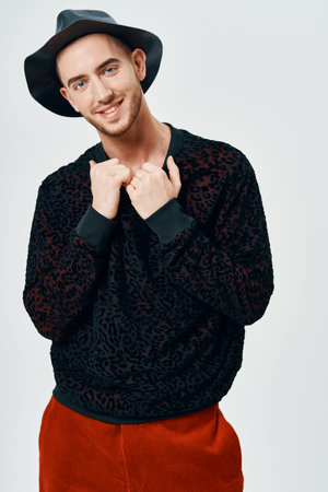 man in black sweater red pants posing studio self-confidenceの写真素材