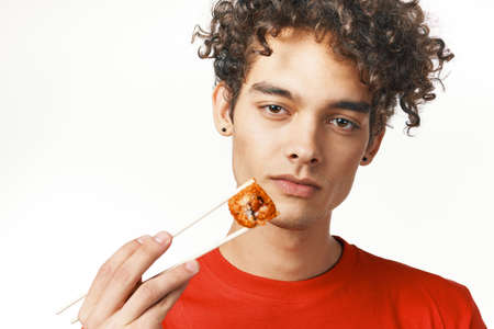 guy in red t-shirt fast food diet food snack light backgroundの写真素材
