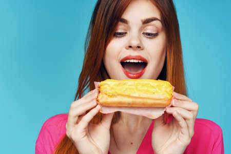 cheerful woman with eclairs in hands close-up snack glamor