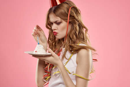 woman cake with candle birthday emotion fun pink backgroundの写真素材