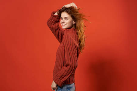 red-haired woman in red sweater fashion studio posing