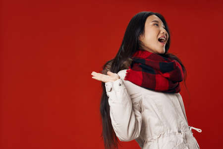 woman wearing winter clothes checkered scarf fashion red backgroundの写真素材