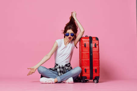 woman with red suitcase luggage passenger airport pink backgroundの写真素材