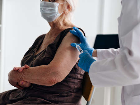 elderly woman patient wearing medical mask vaccine passport injection immunity protectionの写真素材