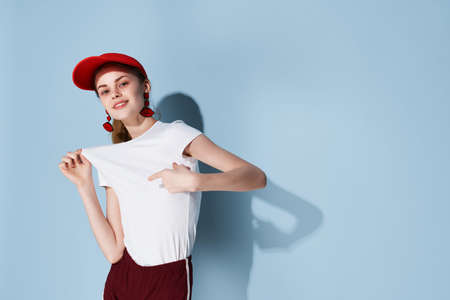pretty woman in red cap posing fashion summer blue backgroundの写真素材