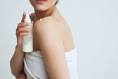 woman with towel naked shoulders lotion clean skin careの写真素材