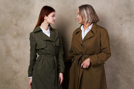 young and old women stand side by side autumn fashion studio isolated backgroundの写真素材
