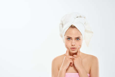 woman holding face with towel on head clean skin dermatologyの写真素材