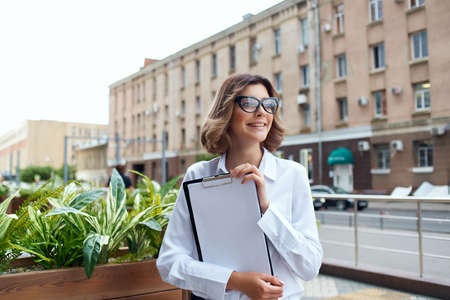 cheerful business woman documents communication on the streetの写真素材