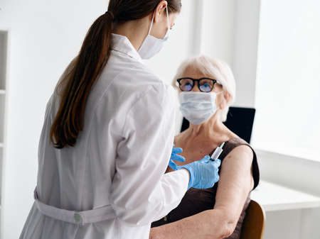 Nurse giving an injection to an elderly womanの写真素材