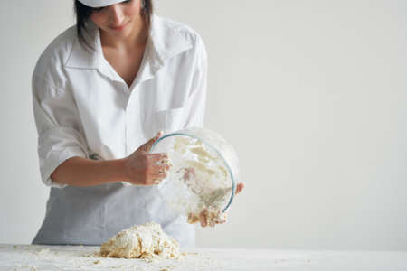 woman baker kneading dough on the table professional work