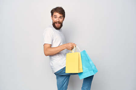 a man in a white t-shirt with packages in his hands walking entertainment lifestyle