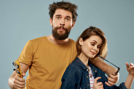 cheerful young couple musicians ukulele blue background