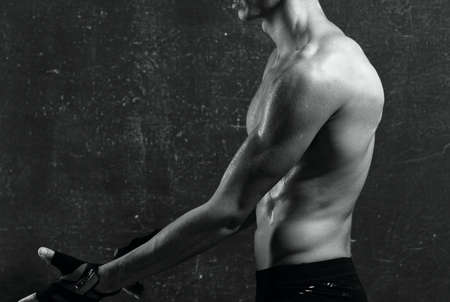 man with a pumped-up torso in gloves workout exercises muscles
