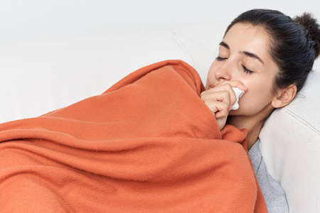 woman lying on bed feeling unwell from health problemの写真素材