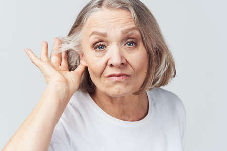 elderly woman in white t-shirt pain health problems dissatisfaction treatment