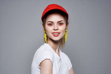 cheerful girl in a red cap holding her hair posing summer styleの写真素材