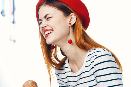 pretty french woman holding a loaf of striped t-shirt light backgroundの写真素材