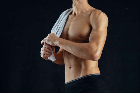 a man with a pumped up press in black shorts gym dark background. High quality photo