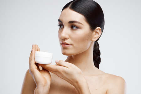 Brunette Bare Shoulders Cream Jar Dermatologyの写真素材