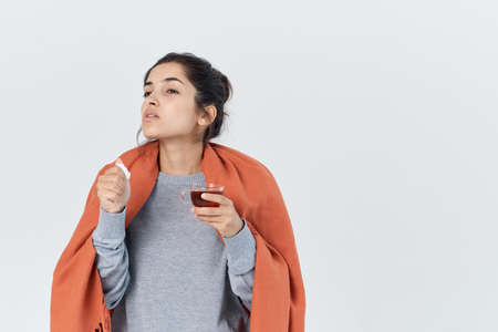 woman having a cold with a cup of tea health problem treatmentの写真素材