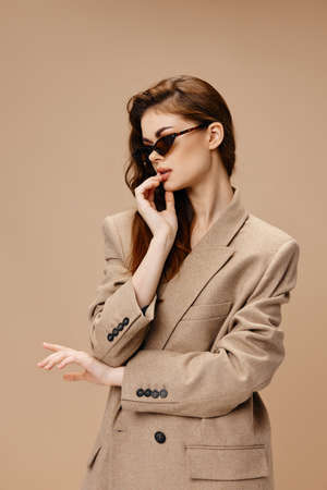 portrait of a beautiful woman in a coat and sunglasses hairstyle makeupの写真素材