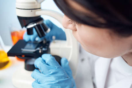 female doctor medical gown chemical solution microscope examination