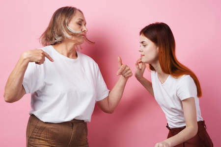 grandmother and granddaughter close communication together love pink backgroundの写真素材
