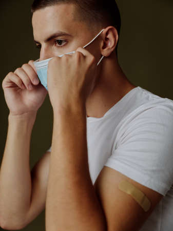 young guy straightens medical mask on his face vaccine epidemic passport