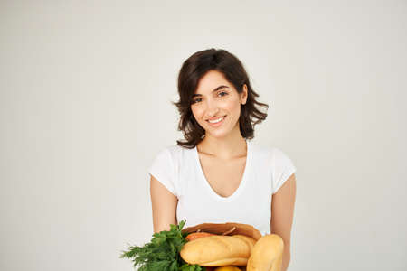 brunette with a package of groceries vegetables healthy food studioの写真素材