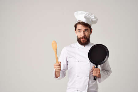 Cheerful male chef Frying pan in hands cooking food professional cooking