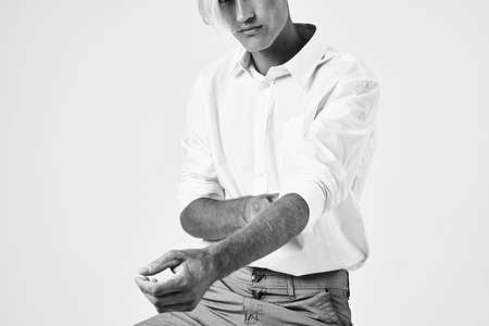 man trendy hairstyle white shirt straightens hands Studio